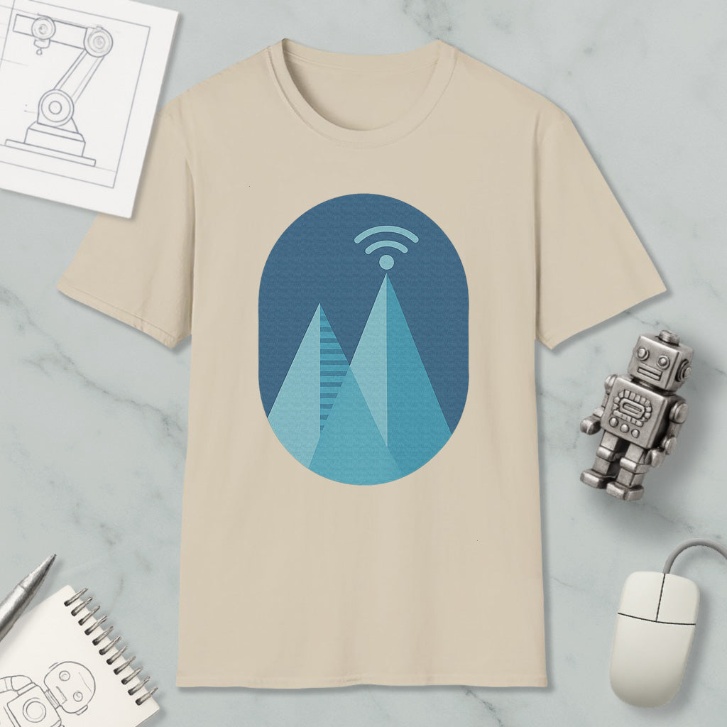 a beige t-shirt with a graphic design of a mountain range, a Wi-Fi symbol, and a robot figure, along with some other items such as a notebook, a mouse, and a pen.