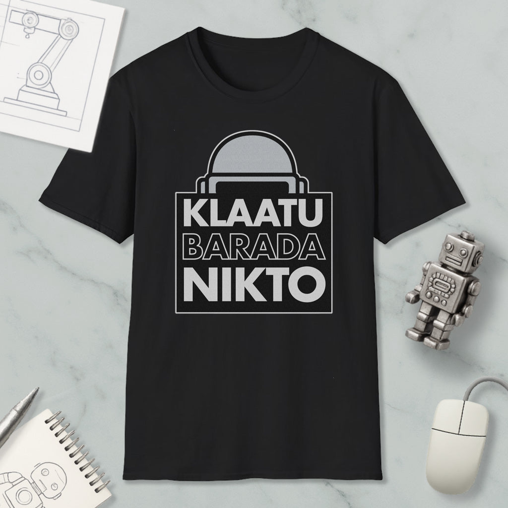 a black t-shirt with a graphic design, a computer mouse, a notebook, and a small robot figurine.