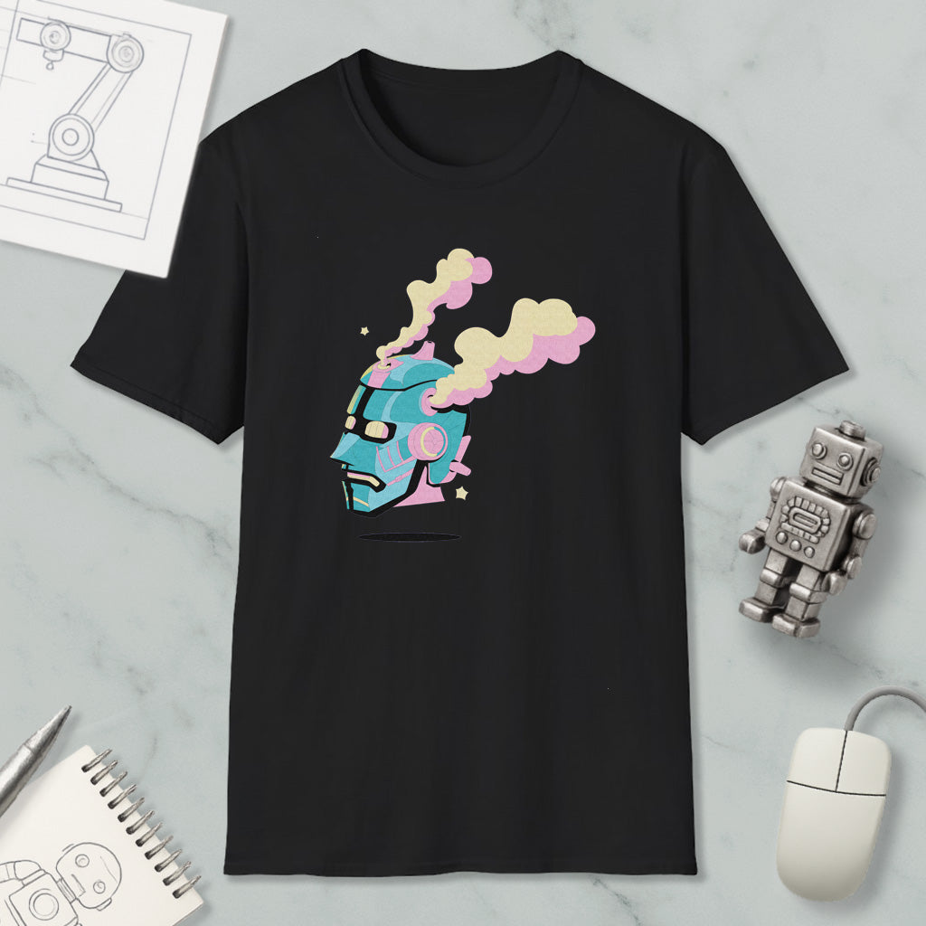 a black t-shirt with a colorful graphic design depicting a robot or robot-like figure with a face and smoke coming out of its head. The t-shirt is placed on a marble surface, along with a computer mouse, a notepad, and a small robot figurine.