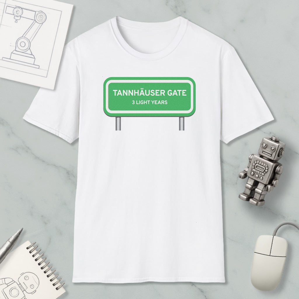 a white t-shirt with a green road sign that reads "Tannhäuser Gate" and "3 light years" printed on it. The t-shirt is placed on a marble surface, along with a computer mouse, a pen, and a notebook.
