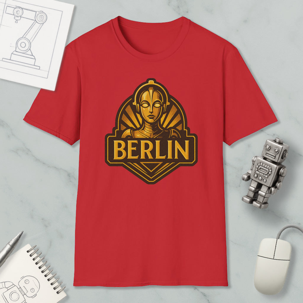 a red t-shirt with a graphic of a robot or character, along with a computer mouse and other office supplies, all arranged on a marble surface.
