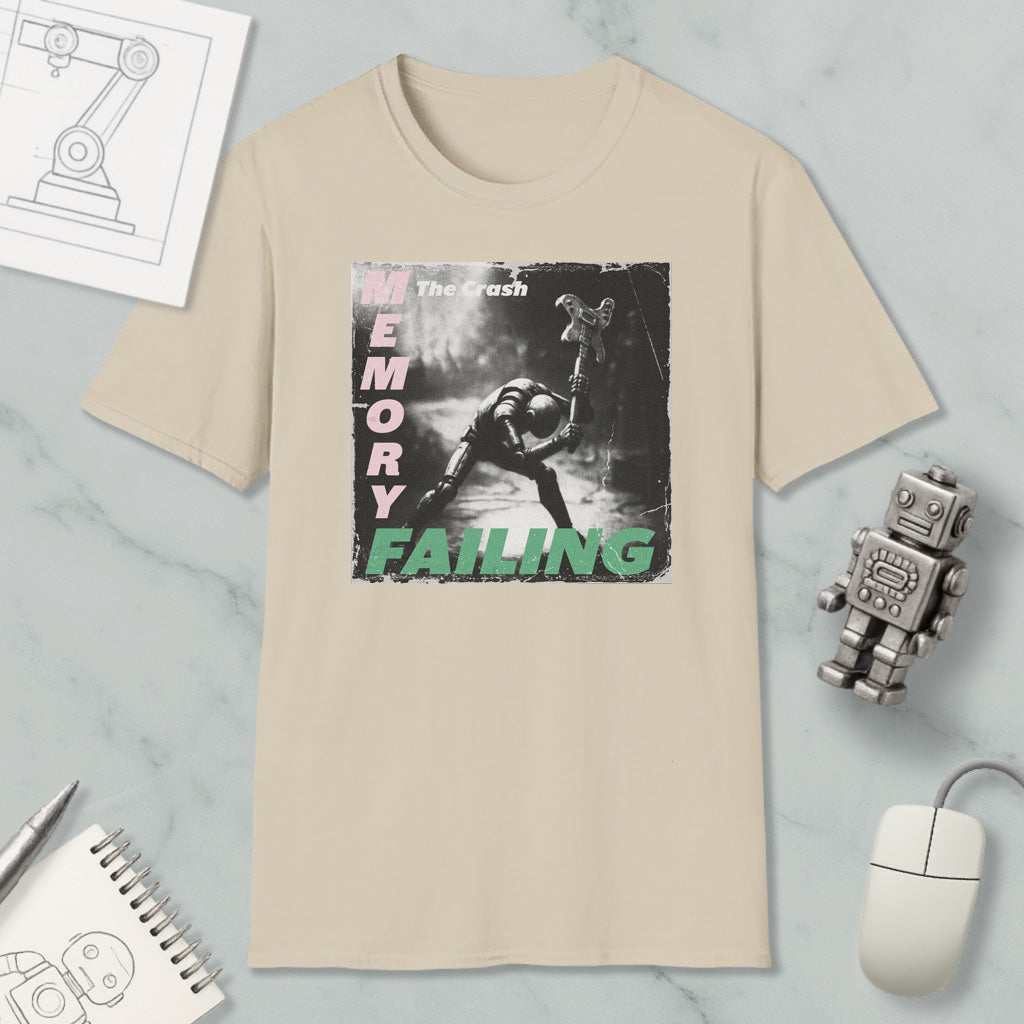 a beige t-shirt with a graphic design depicting a person in a dark environment, along with the text "The Crash" and "Memory Failure". The t-shirt is displayed on a marble surface, accompanied by a computer mouse, a robot, and a notebook.