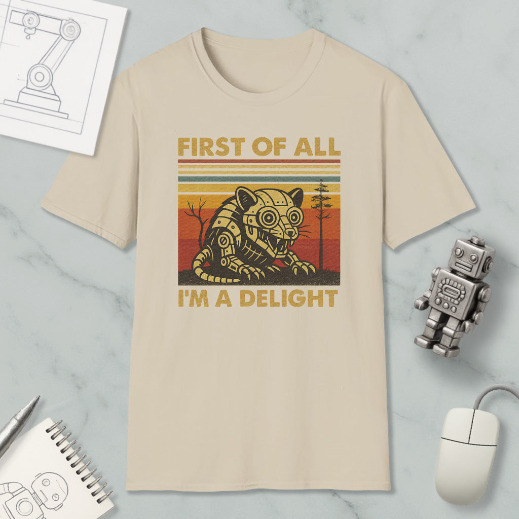 a beige t-shirt with a graphic design depicting a robot or mechanical figure, accompanied by the text "FIRST OF ALL I'M A DELIGHT".
