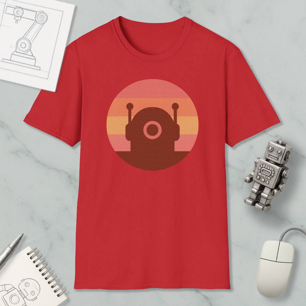 a red t-shirt with a graphic design of a robot or robot-like figure, along with a computer mouse, a notebook, and a pen on a marble surface.