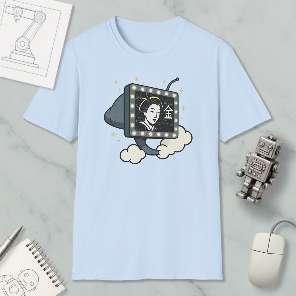 a light blue t-shirt with a graphic design depicting a woman's face on a television screen, surrounded by clouds and stars. The t-shirt is placed on a marble surface, with a computer mouse, a robot, and a notebook nearby.