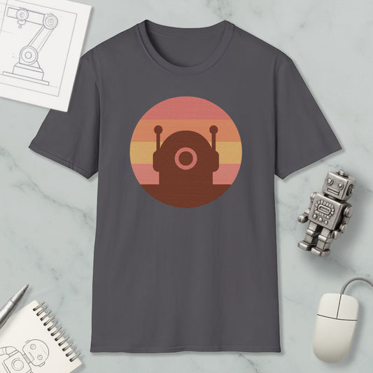 a gray t-shirt with a circular graphic design on it, along with various objects such as a computer mouse, a notebook, and a robot figurine.