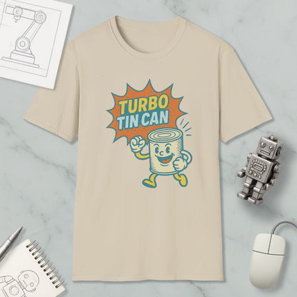 a beige t-shirt with a graphic design depicting a tin can character with a surprised expression, accompanied by the text "TURBO TIN CAN". The t-shirt is displayed on a marble surface, along with a small robot toy and a computer mouse.