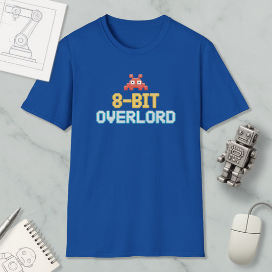 a blue t-shirt with a pixelated character and text, along with a computer mouse, a robot, and some other items on a marble surface.
