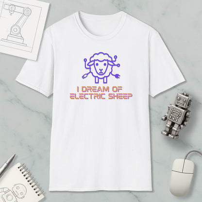 a white t-shirt with a graphic design of a sheep and the text "I DREAM OF ELECTRIC SHEEP" printed on it. The t-shirt is placed on a marble surface, along with a computer mouse, a pen, and a notebook.