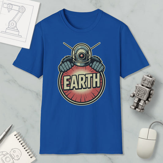 a blue t-shirt with a graphic design of a robot or alien figure holding a sign that says "EARTH". The t-shirt is displayed on a marble surface, along with a computer mouse, a pen, and a notebook.