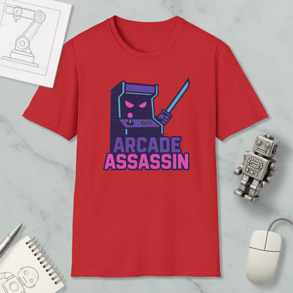 a red t-shirt with a graphic design of a arcade game character, accompanied by the text "ARCADE ASSASSIN" in a stylized font. The t-shirt is displayed on a marble surface, with a computer mouse and a pen nearby.