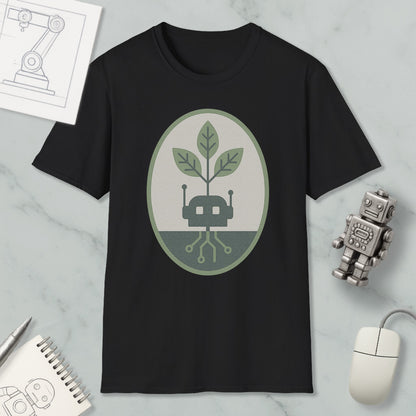 a black t-shirt with a graphic design of a plant growing out of a circuit board, surrounded by a green and gray oval. The t-shirt is placed on a marble surface, with a small robot figurine and a computer mouse nearby.