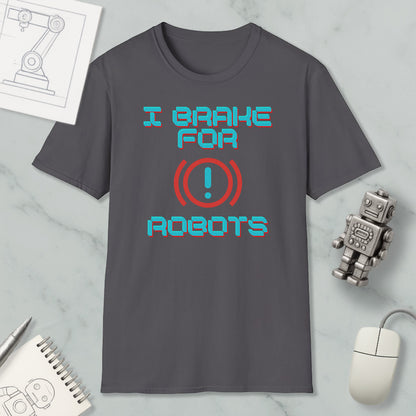 a gray t-shirt with a humorous text design, a small robot, a computer mouse, and some other items on a marble surface.