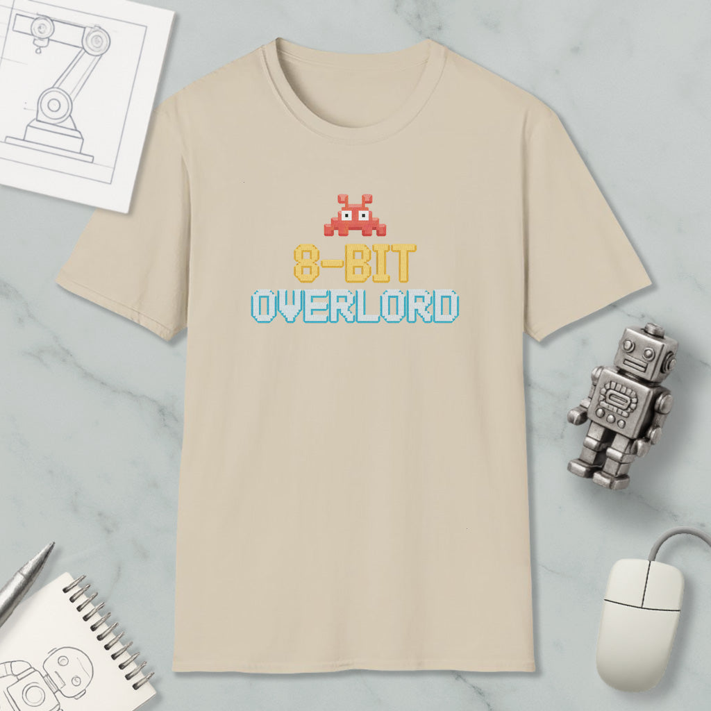 a beige t-shirt with a retro 8-bit character design, along with a computer mouse, a robot, and some technical drawings.