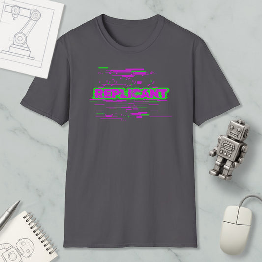 a gray t-shirt with a graphic design, a computer mouse, a notebook, and a small robot on a marble surface.