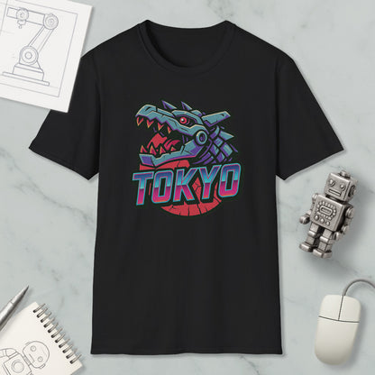 a black t-shirt with a graphic design of a dragon head and the word "TOKYO" written on it. The t-shirt is placed on a marble surface, along with a computer mouse, a notebook, and a small robot figurine.
