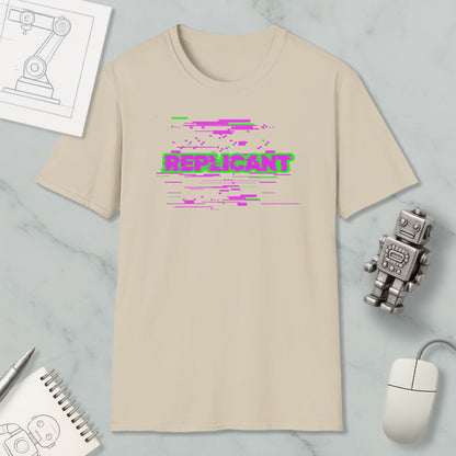 a beige t-shirt with a graphic design, a computer mouse, a notebook, and a small robot on a marble surface.