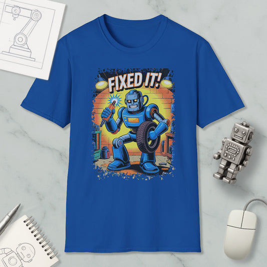 a blue t-shirt with a cartoon robot holding a wrench and the text "FIXED IT!" printed on it. The t-shirt is displayed on a marble surface, along with a computer mouse, a notepad, and a small robot figurine.