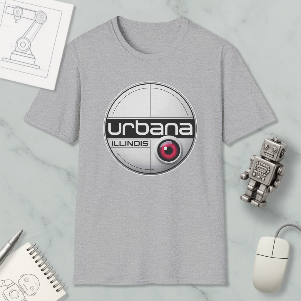 a grey t-shirt with a circular logo, a computer mouse, a robot, and a notebook on a marble surface.