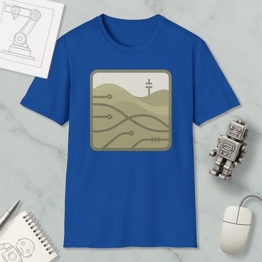 a blue t-shirt with a graphic design, a computer mouse, a notebook, and a small robot on a marble surface.