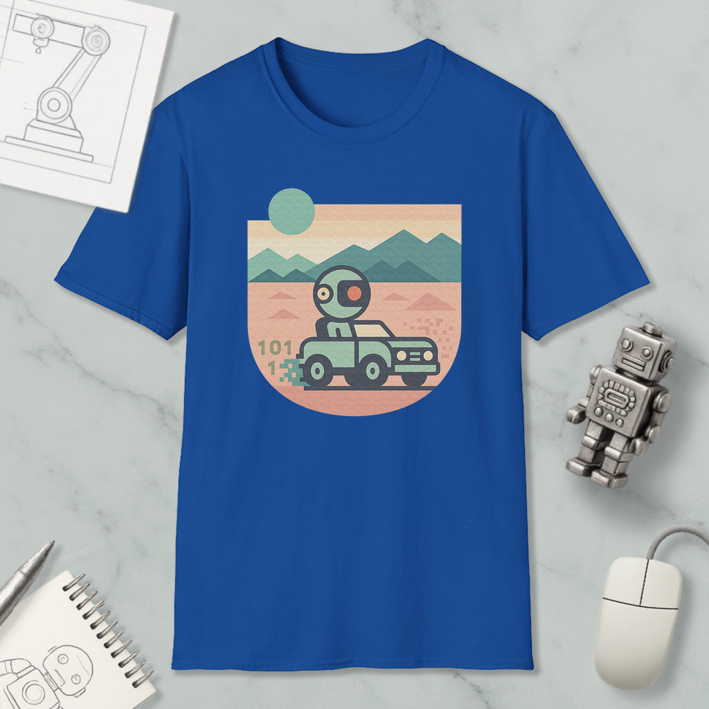 a blue t-shirt with a graphic design depicting a robot driving a car on a desert road, surrounded by mountains. The t-shirt is placed on a marble surface, with a computer mouse and a notebook nearby.