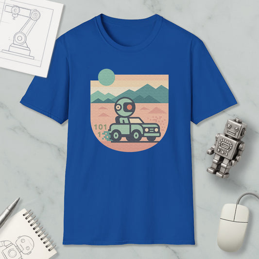 a blue t-shirt with a graphic design depicting a robot driving a car on a desert road, surrounded by mountains. The t-shirt is placed on a marble surface, with a computer mouse and a notebook nearby.