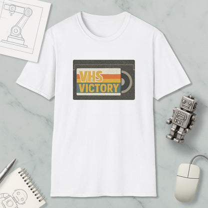 a white t-shirt with a graphic design, a small robot, a computer mouse, and a notebook on a marble surface.