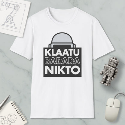 a white t-shirt with a graphic design, a computer mouse, a notebook, and a small robot figurine.