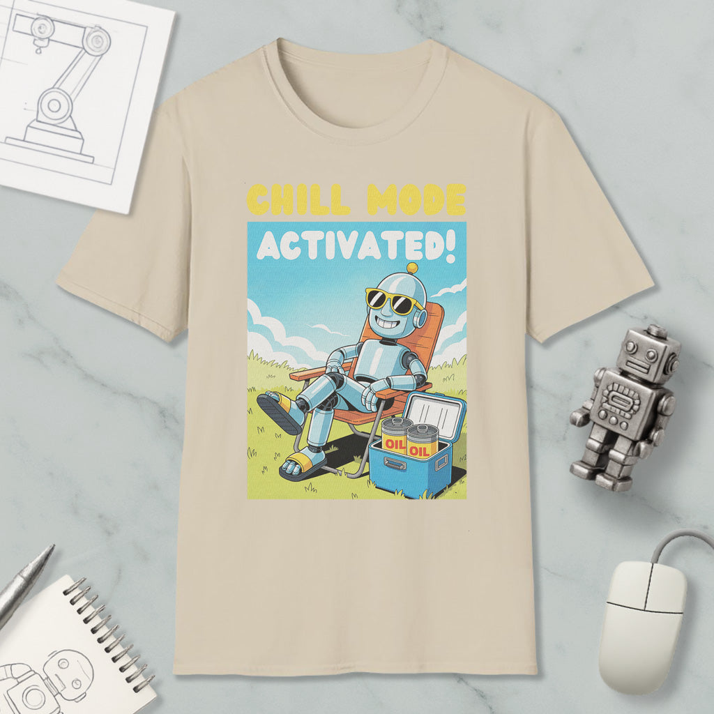 a t-shirt with a cartoon robot sitting in a chair and holding a cooler, with the text "Chill mode activated!" printed on it. The t-shirt is displayed on a marble surface, along with a computer mouse, a pen, and a notebook.