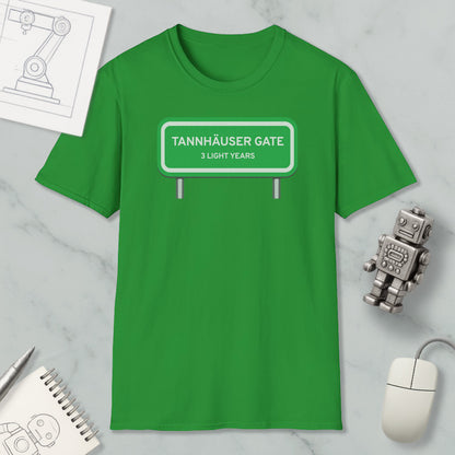 a green t-shirt with a graphic design, a computer mouse, a notebook, and a small robot on a marble surface.