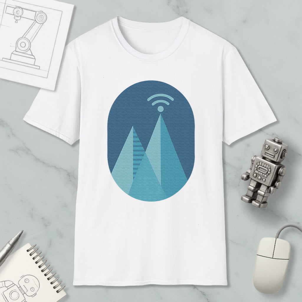 a white t-shirt with a graphic design of a mountain range, a Wi-Fi symbol, and a robot figure. The t-shirt is placed on a marble surface, surrounded by various objects such as a notebook, a mouse, and a pen.