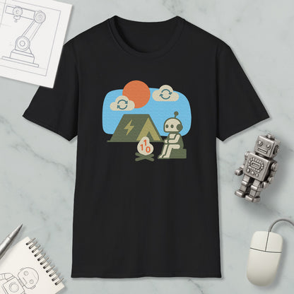 a black t-shirt with a graphic design depicting a robot sitting next to a tent, with a small robot figurine nearby. The t-shirt is displayed on a marble surface, along with a notebook, a pen, and a computer mouse.