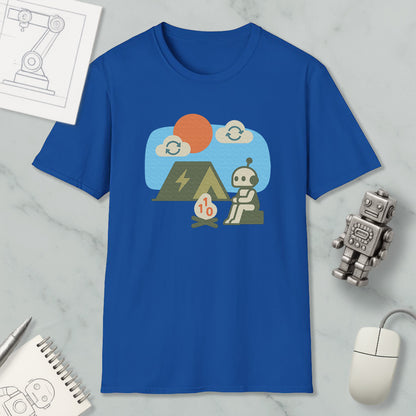 a blue t-shirt with a graphic design depicting a robot sitting on a rock, with a small tent and a campfire nearby. The t-shirt is displayed on a marble surface, along with a computer mouse, a notebook, and a small robot figurine.