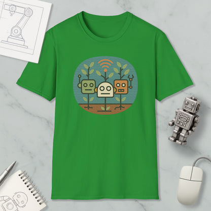 a green t-shirt with a graphic design of three cartoon robots, along with a computer mouse, a notebook, and a pen on a marble surface.