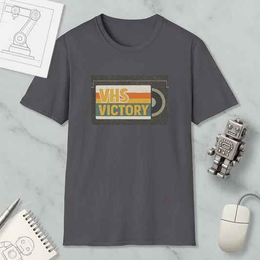 a gray t-shirt with a graphic design, a small robot, a computer mouse, and a notebook on a marble surface.
