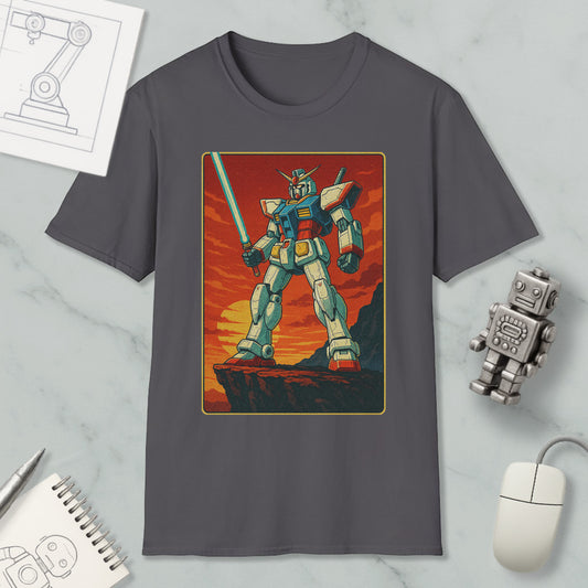a gray t-shirt with a graphic design of a robot or mechanical figure, standing on a cliff or rocky outcropping against a sunset or sunset-like background.