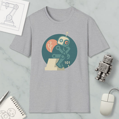 a gray t-shirt with a graphic design of a robot, a computer mouse, and a notebook, all placed on a marble surface.