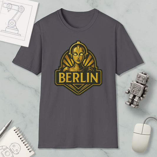 a gray t-shirt with a graphic design of a robot or robot-like figure, along with the word "BERLIN" written below it. The t-shirt is displayed on a marble surface, surrounded by various objects such as a computer mouse, a notebook, and a pen.
