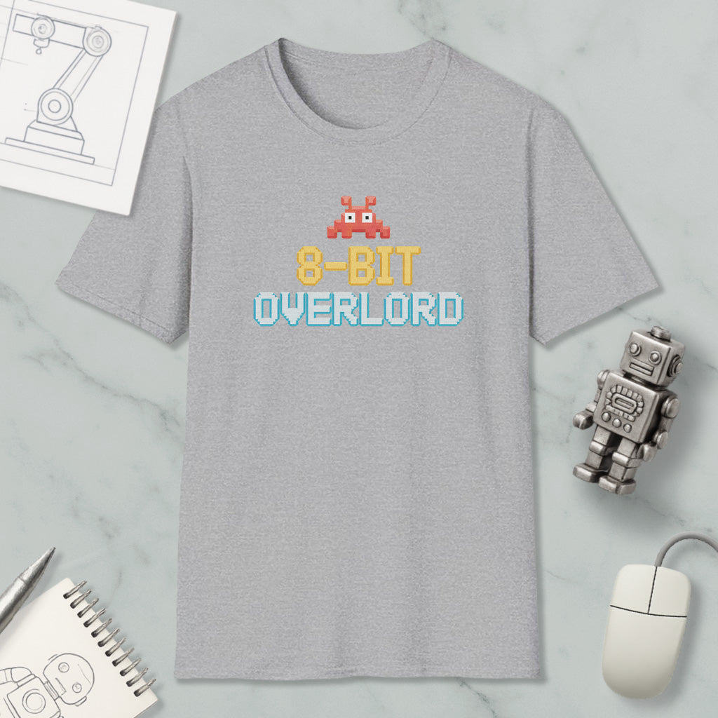 a gray t-shirt with a retro 8-bit character design, along with a computer mouse, a robot, and a notebook.