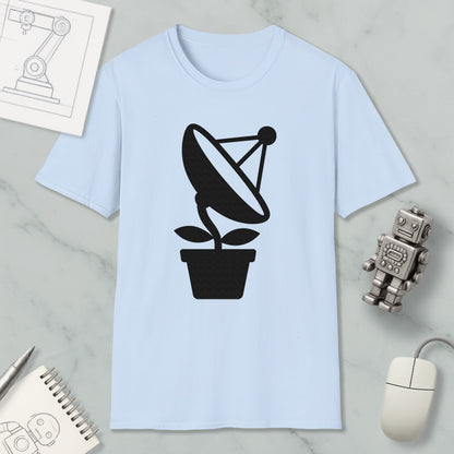 a light blue t-shirt with a black satellite dish graphic, a small robot, a mouse, and a notebook on a marble surface.