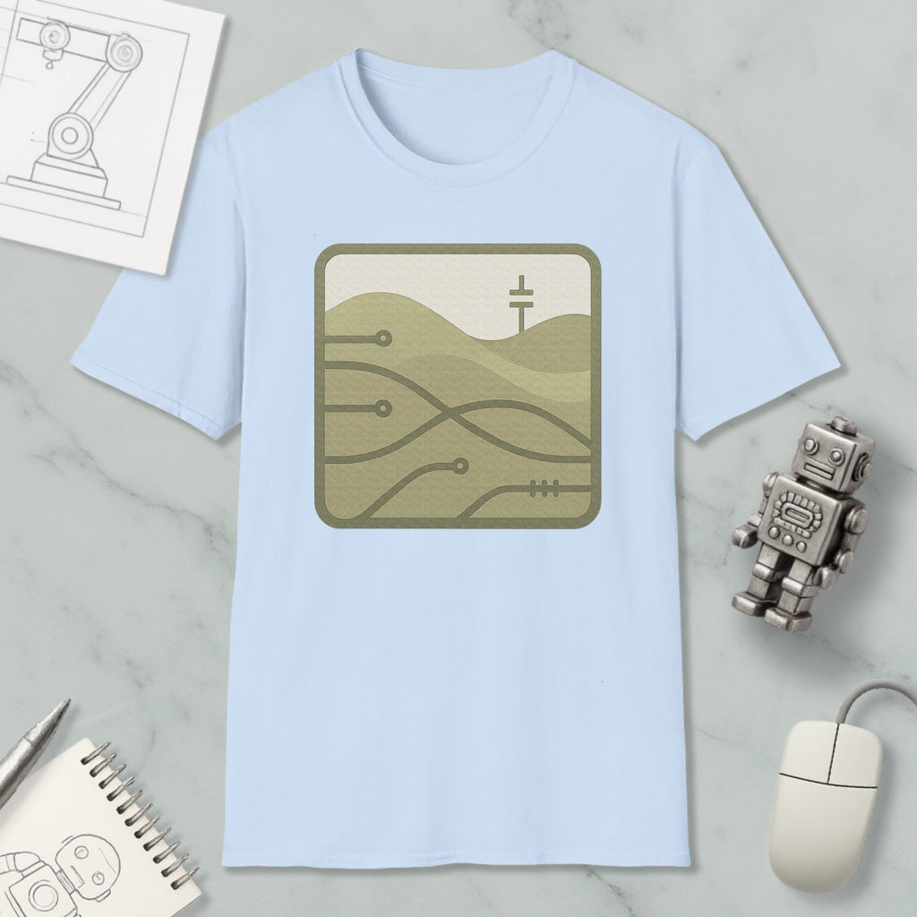 a light blue t-shirt with a graphic design, a small robot, a computer mouse, and a notebook on a marble surface.