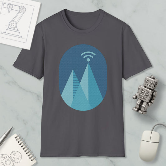 a gray t-shirt with a graphic design of a mountain range, a Wi-Fi symbol, and a robot figure. The t-shirt is placed on a marble surface, surrounded by various objects such as a notebook, a mouse, and a pen.