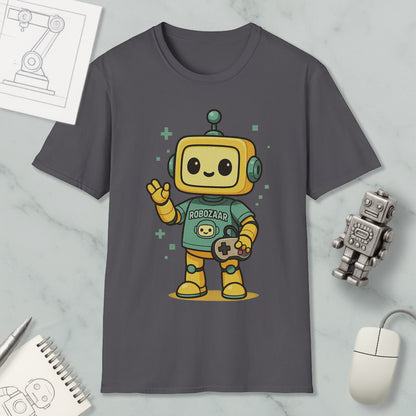 a gray t-shirt with a cartoon robot character wearing a green shirt and holding a game controller. The t-shirt is displayed on a marble surface, along with a computer mouse, a notebook, and a small robot figurine.