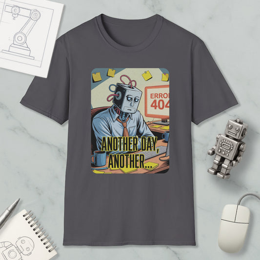 a gray t-shirt with a graphic design depicting a robot or robot-like figure sitting at a desk with a computer monitor, keyboard, and mouse. The robot appears to be in a state of frustration or disappointment, as indicated by the text "Another day, another error" written below the robot.
