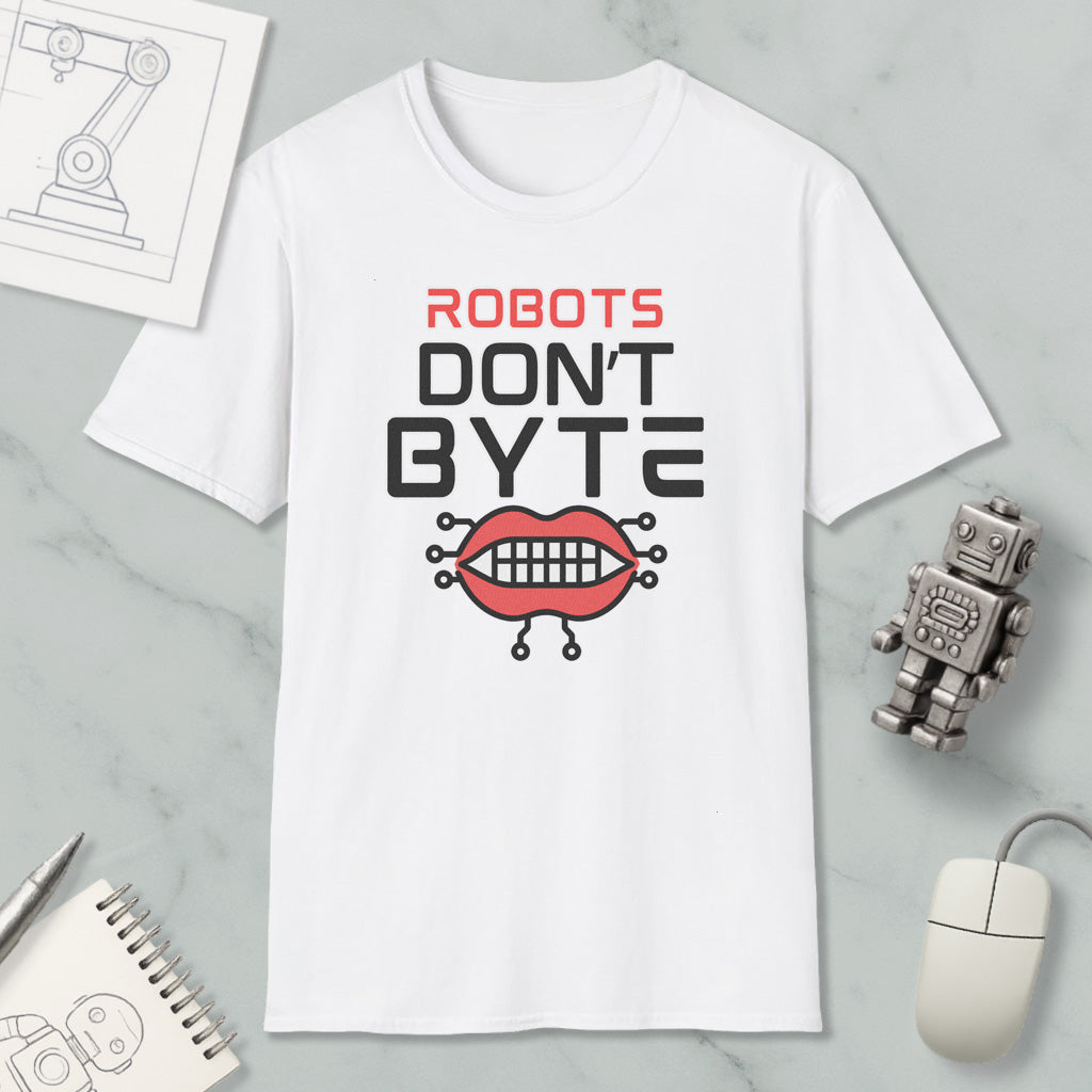 a white t-shirt with a graphic design that says "ROBOTS DON'T BYTE" and includes a robot mouth with teeth. The t-shirt is placed on a marble surface, along with a computer mouse, a spiral notebook, and a small robot figurine.