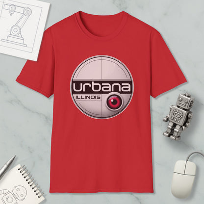 a red t-shirt with a graphic design, a computer mouse, a notebook, and a small robot on a marble surface.