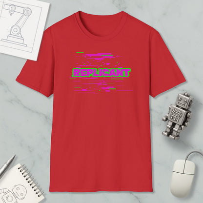 a red t-shirt with a graphic design, a computer mouse, a notebook, and a robot figurine on a marble surface.