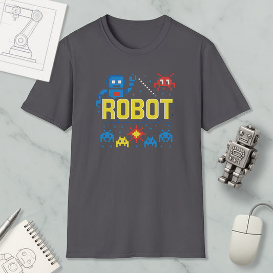a gray t-shirt with a robot graphic and pixel art elements, along with a mouse and a notebook, all placed on a marble surface.