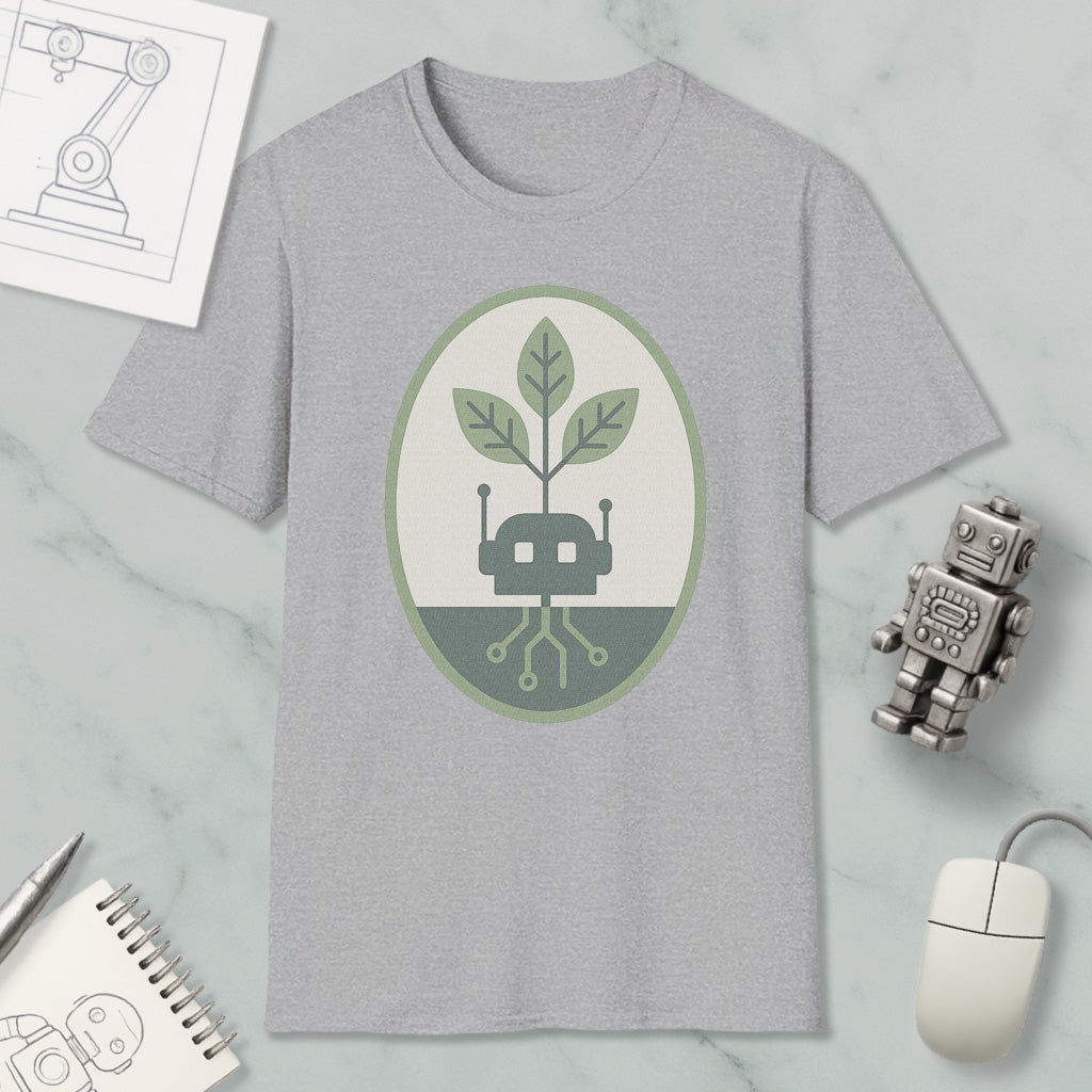 a gray t-shirt with a green and white graphic design, a small robot, a computer mouse, and a notebook on a marble surface.