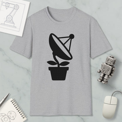 a gray t-shirt with a black satellite dish graphic, a small robot, a mouse, and a notebook on a marble surface.